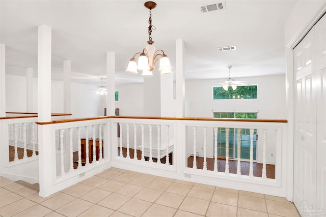 corridor with light tile patterned flooring and a chandelier