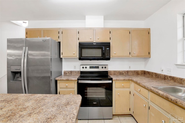 kitchen featuring light brown cabinetry, light tile patterned flooring, stainless steel appliances, and sink