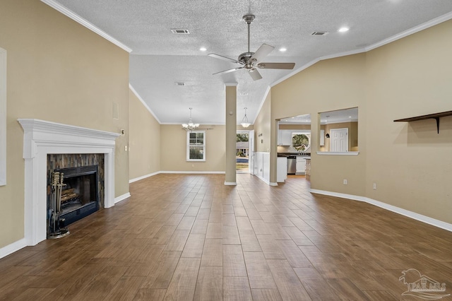 unfurnished living room featuring vaulted ceiling, ceiling fan with notable chandelier, ornamental molding, and a textured ceiling