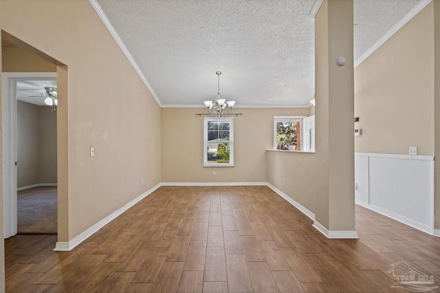 spare room featuring ceiling fan with notable chandelier, crown molding, and a textured ceiling