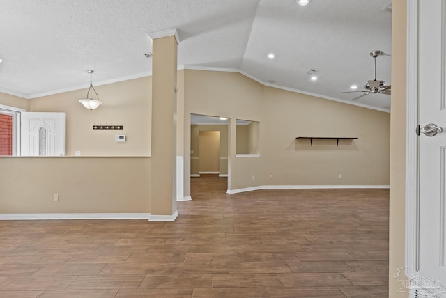 unfurnished living room featuring vaulted ceiling, ceiling fan, crown molding, and a textured ceiling