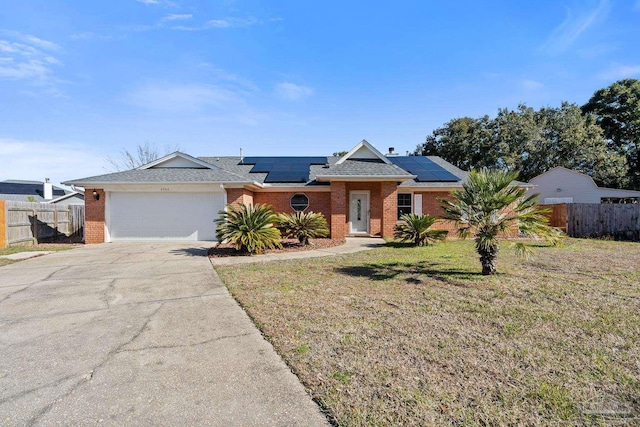 ranch-style house featuring a garage, a front yard, and solar panels