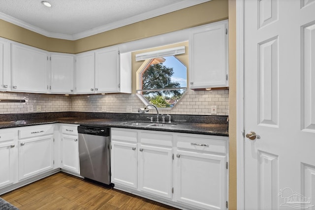 kitchen with a textured ceiling, white cabinetry, dishwasher, and sink