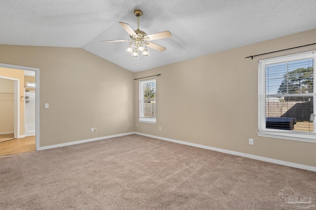 spare room with ceiling fan, a textured ceiling, light carpet, and lofted ceiling