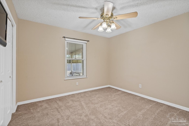 carpeted spare room featuring ceiling fan and a textured ceiling