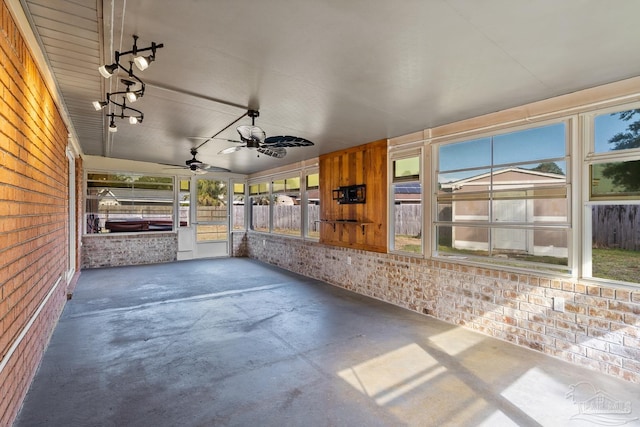 unfurnished sunroom with ceiling fan and a healthy amount of sunlight