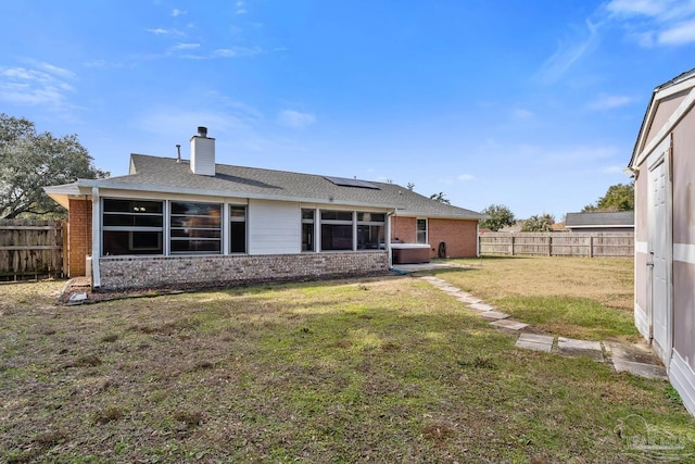 rear view of property with a lawn