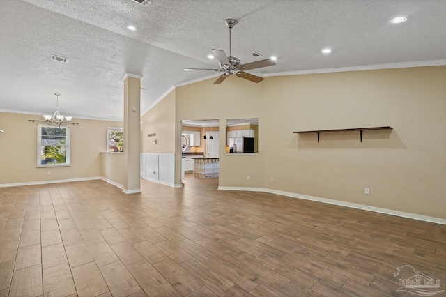 unfurnished living room with vaulted ceiling, ceiling fan with notable chandelier, ornamental molding, and a textured ceiling