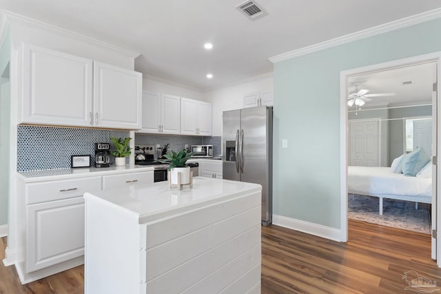 kitchen featuring white cabinetry, crown molding, a center island, hardwood / wood-style flooring, and stainless steel appliances