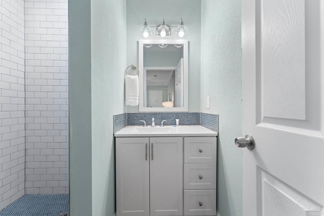 bathroom with vanity and a tile shower