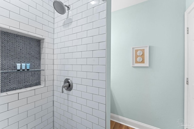 bathroom featuring wood-type flooring and tiled shower