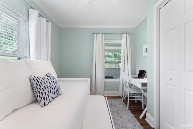 bedroom featuring crown molding, dark wood-type flooring, and ceiling fan