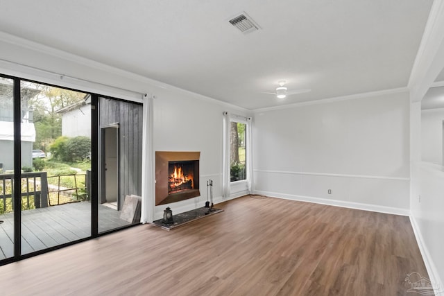 unfurnished living room with wood-type flooring, crown molding, and ceiling fan