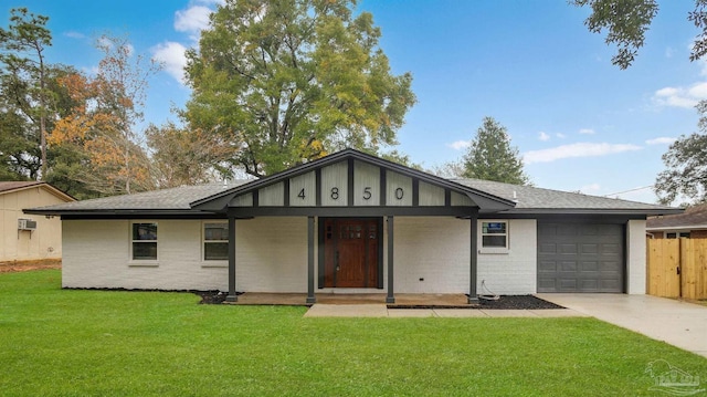 view of front of house featuring a wall unit AC, a garage, covered porch, and a front yard