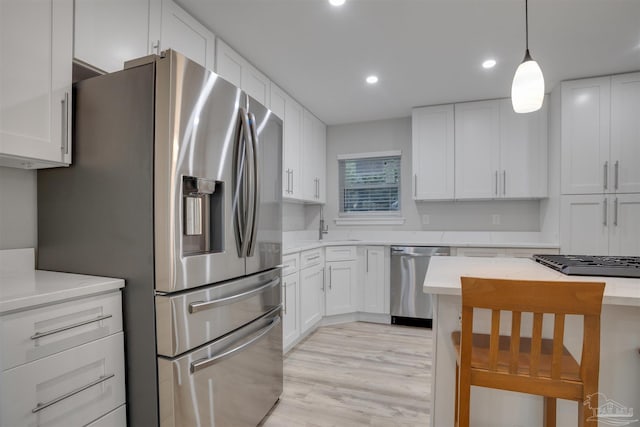 kitchen with white cabinets, stainless steel appliances, and light hardwood / wood-style floors