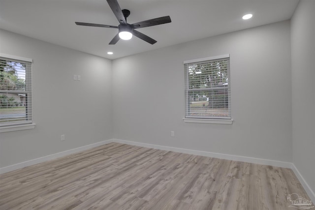 spare room with light hardwood / wood-style floors, ceiling fan, and a healthy amount of sunlight