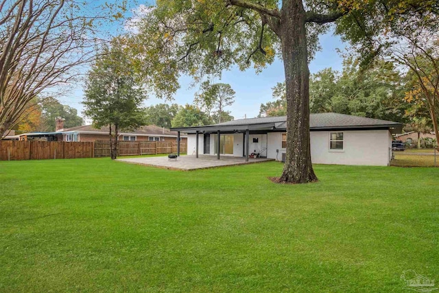 back of house featuring a lawn and a patio area