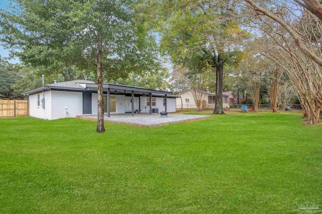 rear view of property with a lawn and a patio area