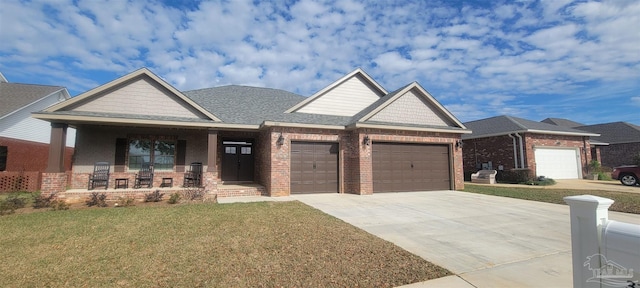 view of front of home with covered porch, a front lawn, and a garage