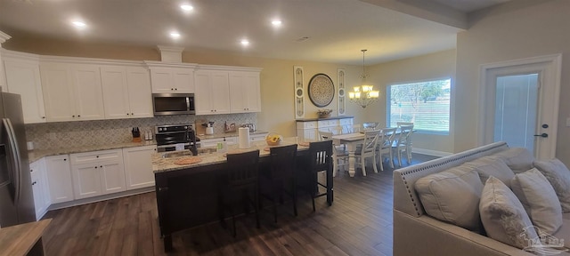 kitchen featuring white cabinetry, stainless steel appliances, dark wood-type flooring, and decorative light fixtures