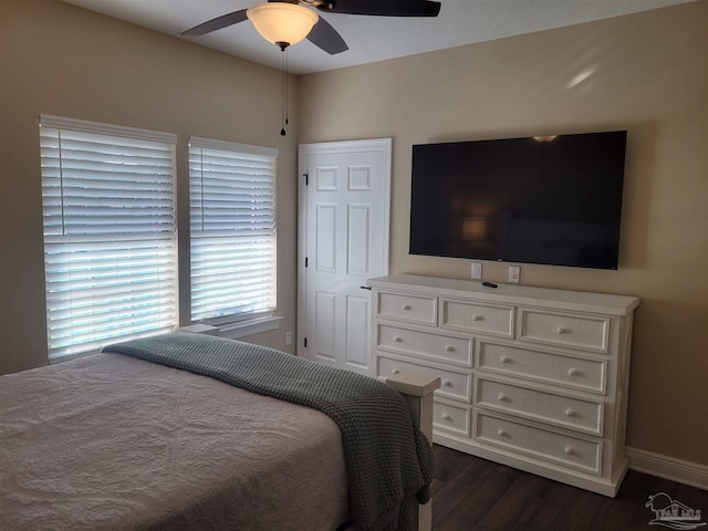 bedroom with dark hardwood / wood-style flooring and ceiling fan