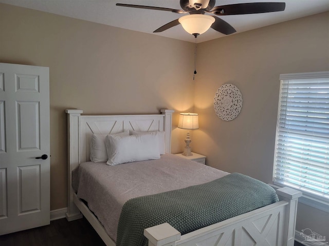 bedroom with dark hardwood / wood-style floors and ceiling fan