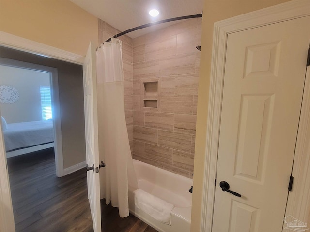 bathroom featuring hardwood / wood-style flooring and shower / bath combo with shower curtain