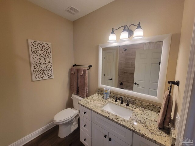 bathroom featuring vanity, hardwood / wood-style flooring, and toilet