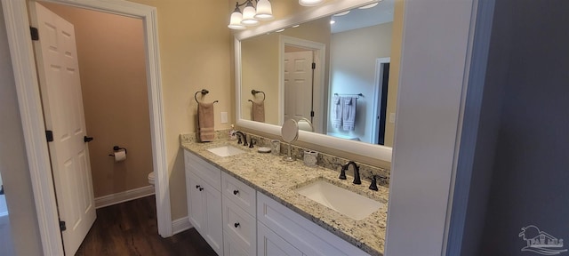 bathroom with toilet, hardwood / wood-style floors, and vanity