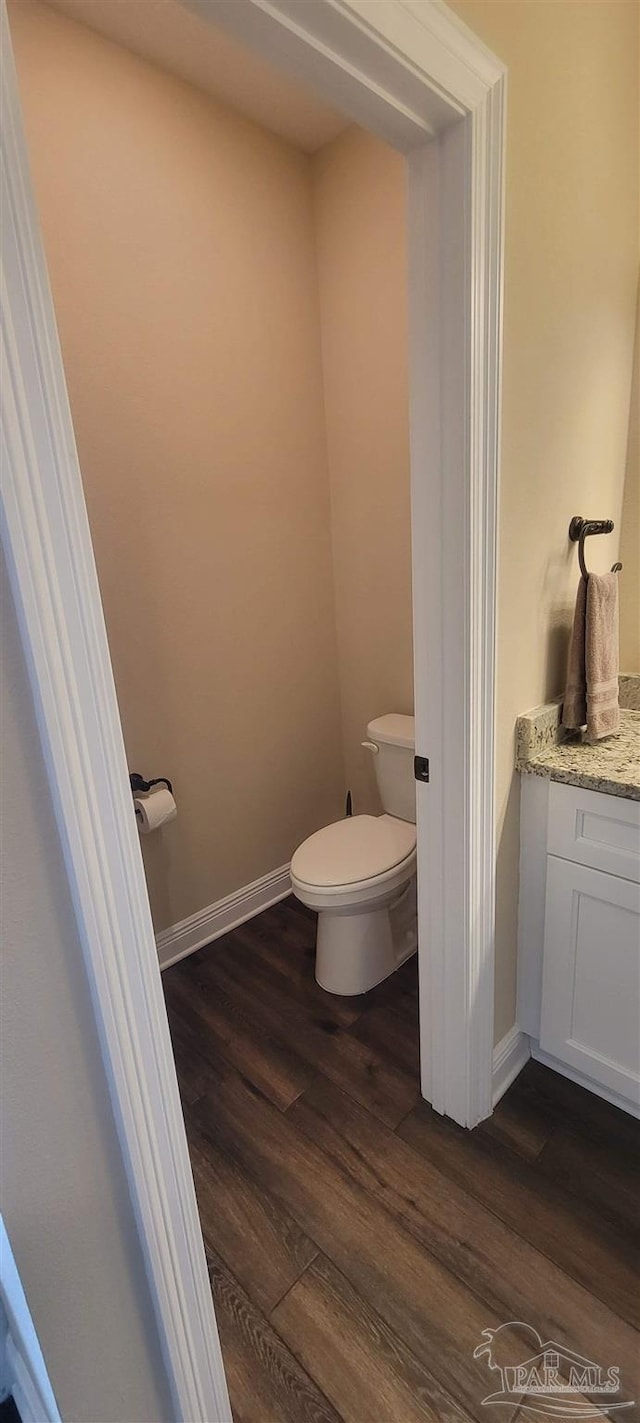 bathroom featuring toilet, hardwood / wood-style flooring, and vanity