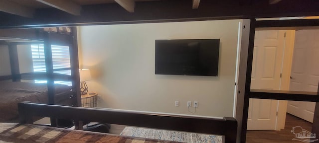 bedroom featuring beam ceiling and wood-type flooring