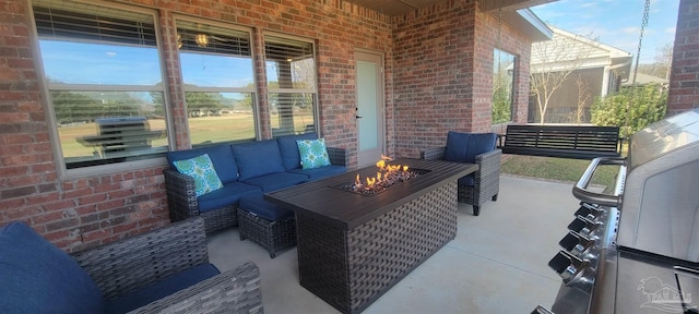 view of patio with an outdoor living space with a fire pit