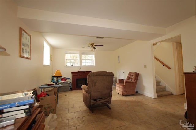 living room featuring visible vents, ceiling fan, stairway, a fireplace, and light tile patterned flooring