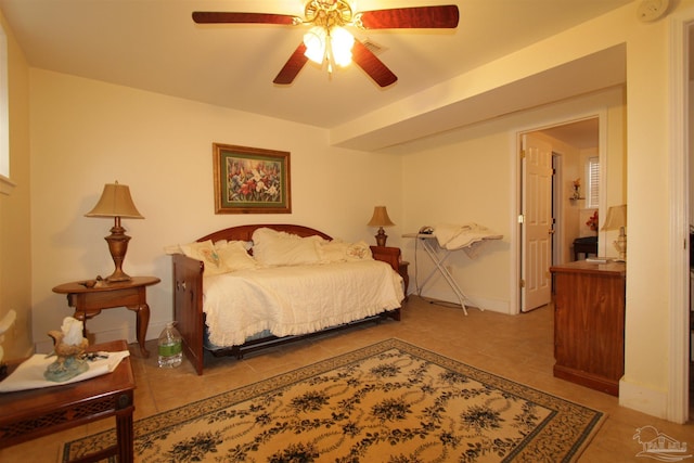 tiled bedroom featuring baseboards and ceiling fan