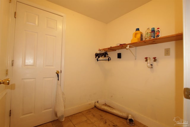 laundry area with laundry area, light tile patterned flooring, and baseboards