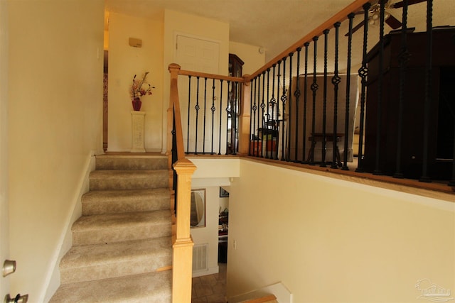 stairway with visible vents and baseboards