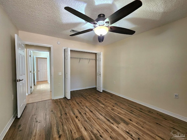 unfurnished bedroom with a textured ceiling, wood-type flooring, and ceiling fan