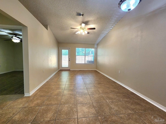 tiled empty room featuring a textured ceiling and ceiling fan