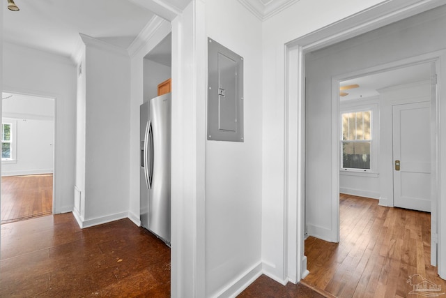 corridor featuring baseboards, crown molding, hardwood / wood-style floors, and electric panel