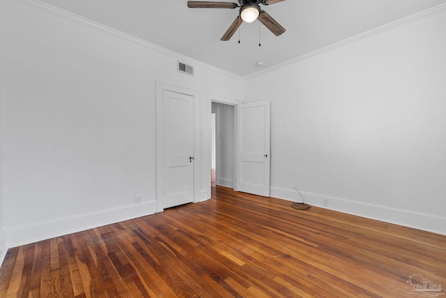 unfurnished room with baseboards, visible vents, a ceiling fan, wood finished floors, and ornamental molding