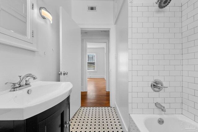 bathroom featuring tile patterned floors, baseboards, visible vents, vanity, and tub / shower combination