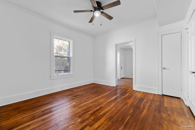 unfurnished bedroom featuring wood finished floors, crown molding, baseboards, and a ceiling fan