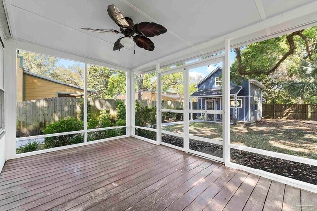 unfurnished sunroom with ceiling fan