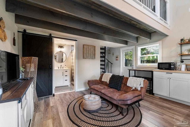 living room with light wood-style floors and a barn door