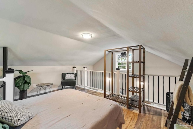 bedroom featuring wood finished floors and lofted ceiling