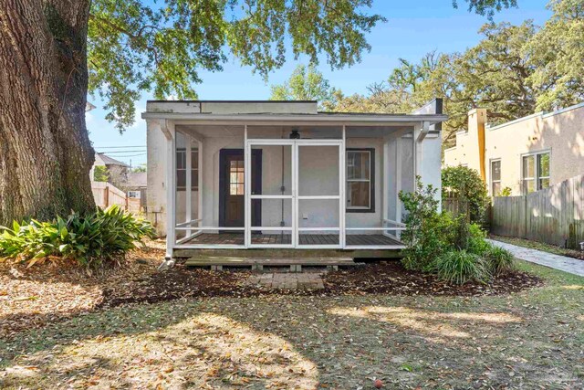 rear view of property with a sunroom and fence