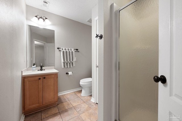 bathroom featuring toilet, a textured ceiling, vanity, and a shower with door