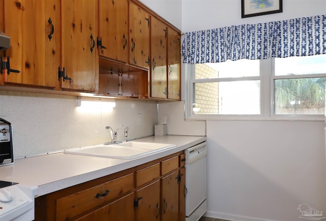 kitchen with sink, backsplash, and white dishwasher