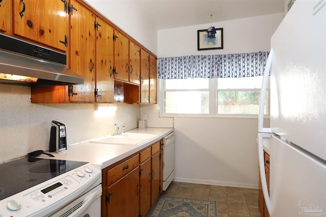 kitchen with white appliances, sink, and backsplash