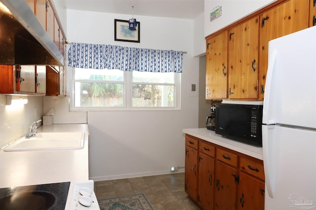 kitchen featuring white refrigerator, extractor fan, and sink